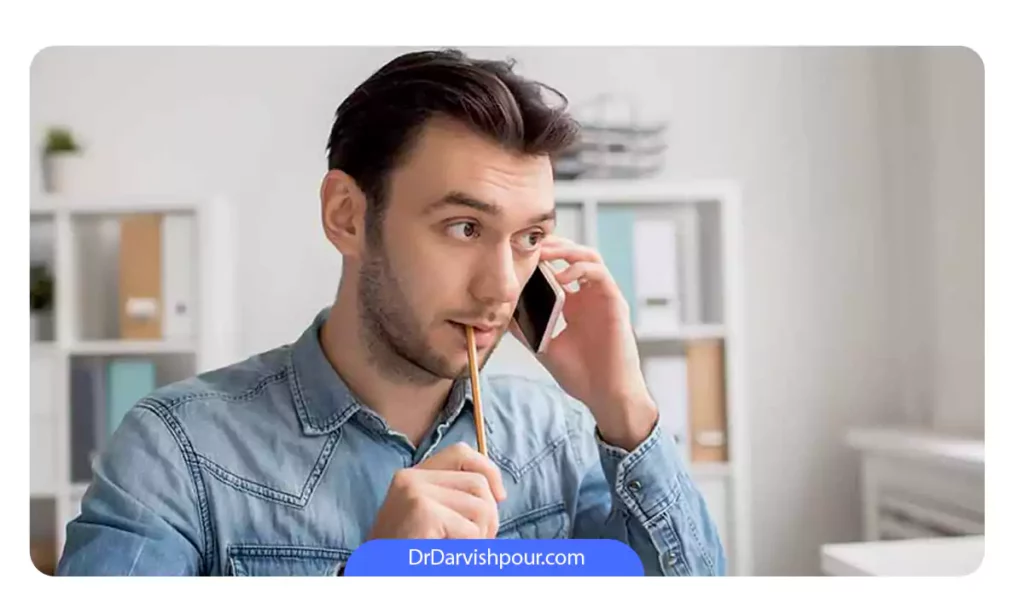 یک مرد که در حال صحبت کردن با تلفن است و همزمان مداد میجود