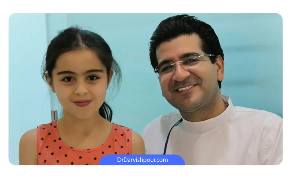 عکس دکتر درویش پور با یکی از بیماران خردسالشان