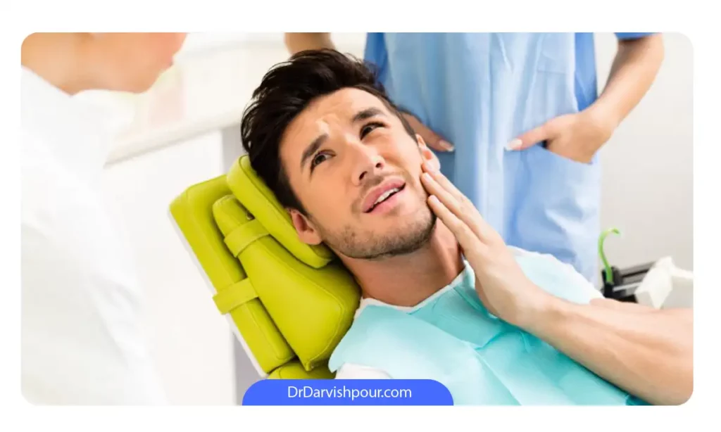 مردی که دندانش عفونت کرده و در حال صحبت با یک دندانپزشک است
